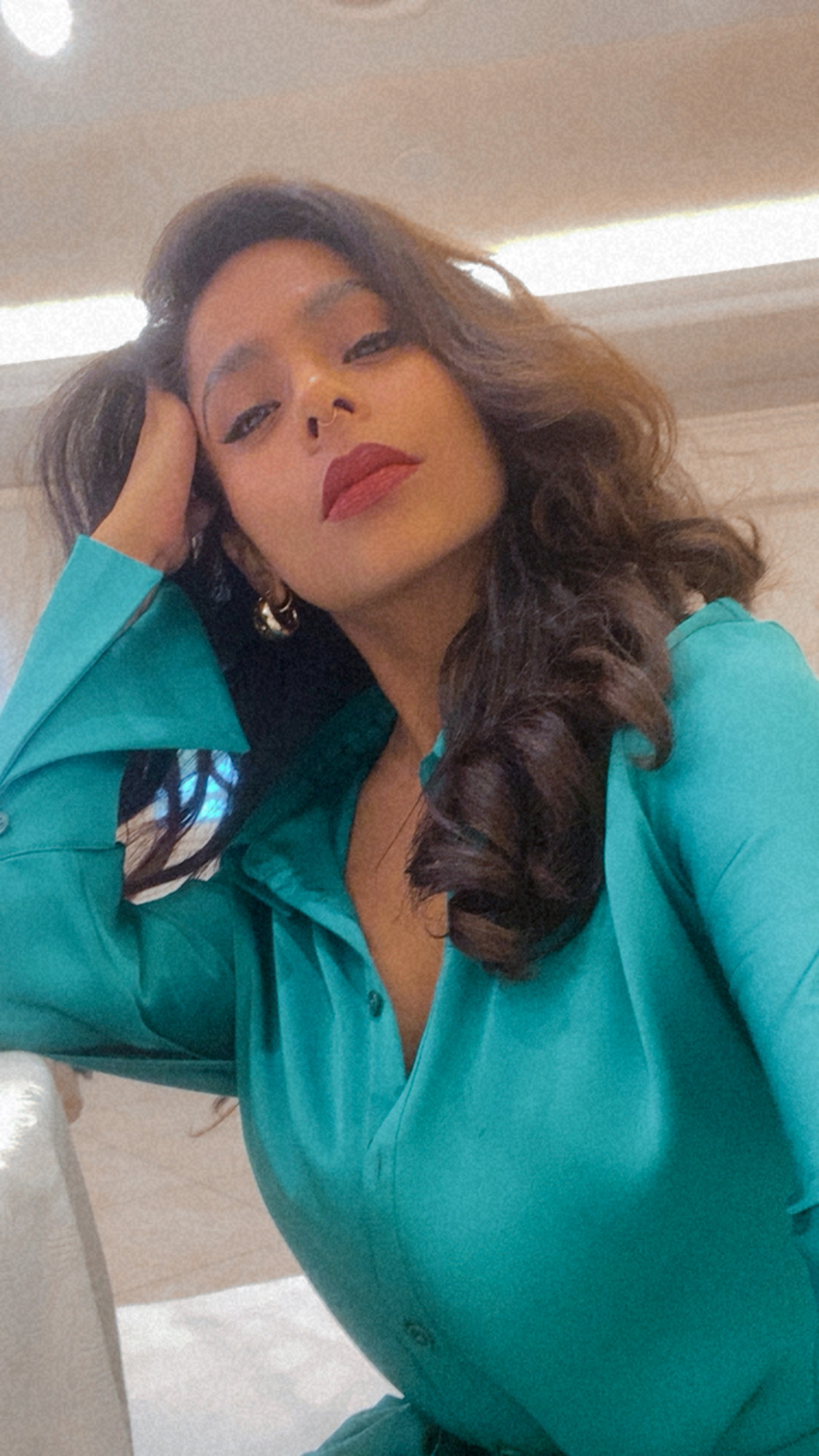 Portrait of the creative director in a teal satin shirt and red lipstick